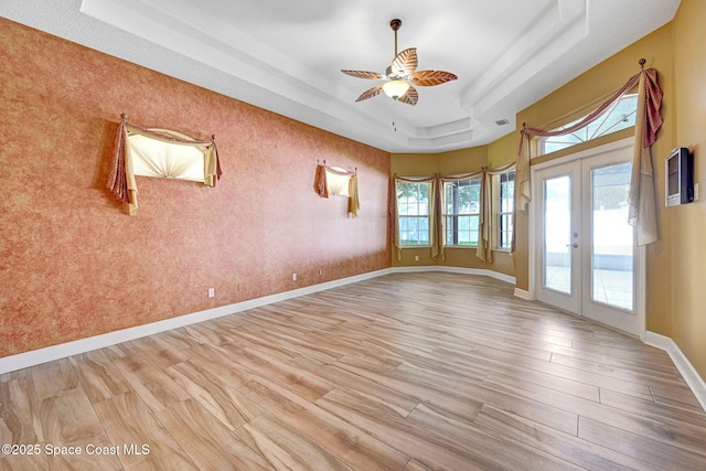 2604 Canary Isles Dr, Melbourne, FL 32901 - unfurnished room with a raised ceiling, light wood-style flooring, french doors, and a ceiling fan