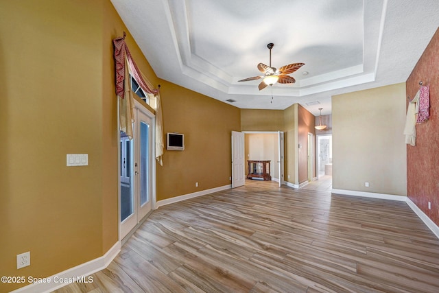 2604 Canary Isles Dr, Melbourne, FL 32901 - unfurnished living room featuring a raised ceiling, wood finished floors, and ceiling fan
