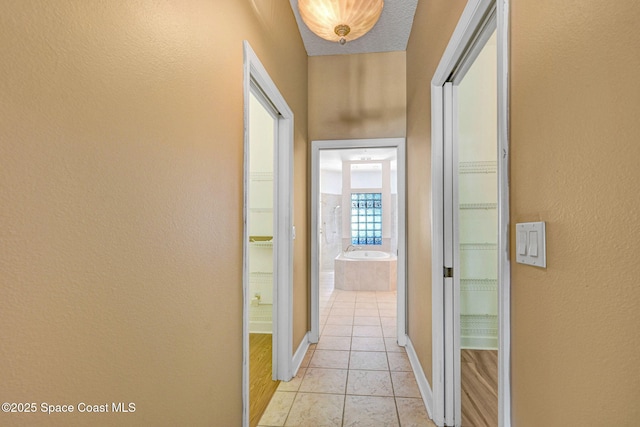 2604 Canary Isles Dr, Melbourne, FL 32901 - hallway with light tile patterned flooring and a textured wall