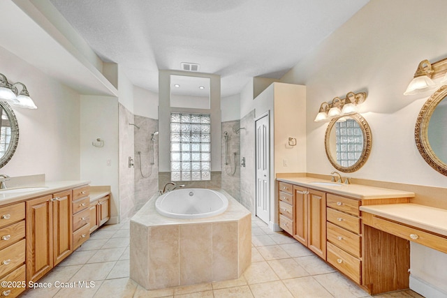 2604 Canary Isles Dr, Melbourne, FL 32901 - bathroom with a tile shower, tile patterned floors, a tub with jets, and two vanities