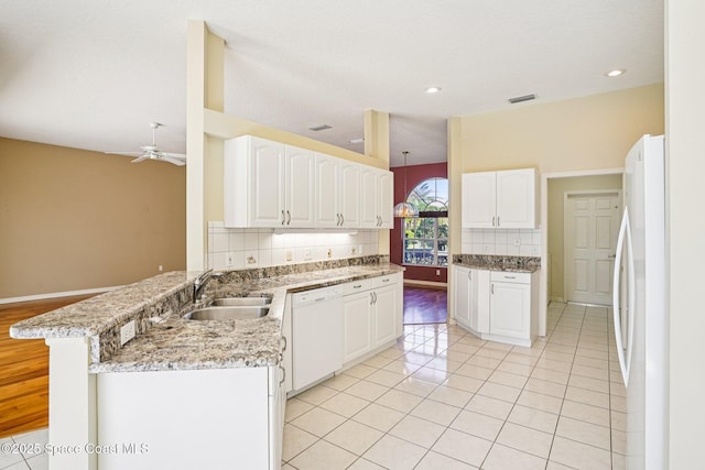 1526 Cypress Trace Dr, Melbourne, FL 32940 - kitchen featuring white appliances, a peninsula, tasteful backsplash, a ceiling fan, and white cabinets