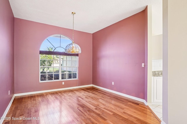 1526 Cypress Trace Dr, Melbourne, FL 32940 - spare room with a chandelier and light wood-style flooring