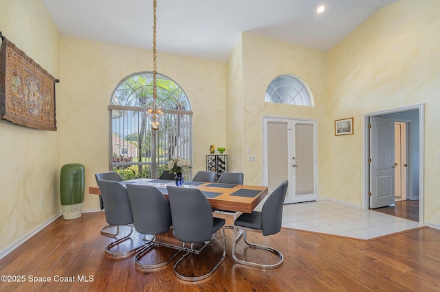 356 Fuller St SE, Palm Bay, FL 32909 - dining room featuring healthy amount of natural light, hardwood / wood-style flooring, a high ceiling, a chandelier, and french doors