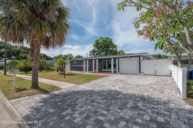 1575 Glen Haven Dr, Merritt Island, FL 32952 - view of front of home with a gate, an attached garage, and decorative driveway