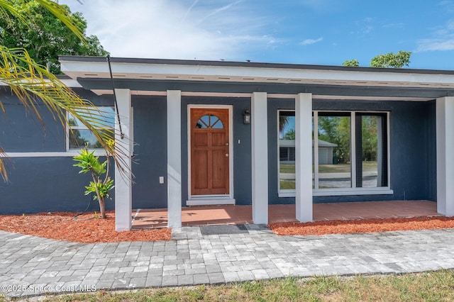 1575 Glen Haven Dr, Merritt Island, FL 32952 - doorway to property featuring a porch and stucco siding