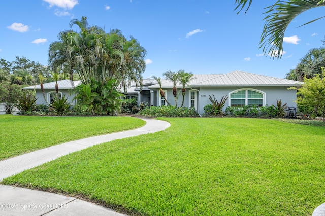9495 Fleming Grant Rd, Sebastian, FL 32976 - ranch-style home with stucco siding, a front yard, and a metal roof