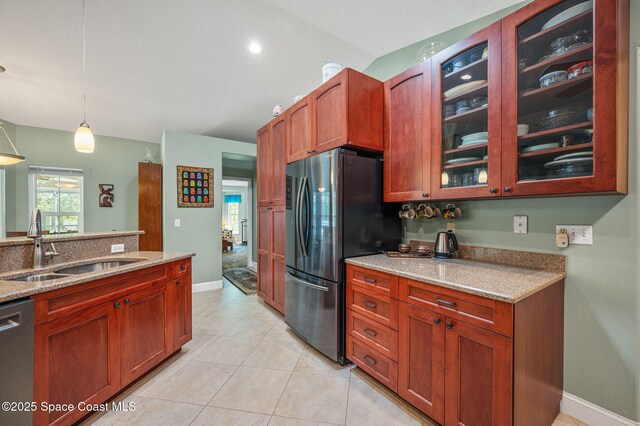 9495 Fleming Grant Rd, Sebastian, FL 32976 - kitchen with stainless steel appliances, light stone counters, decorative light fixtures, and glass insert cabinets