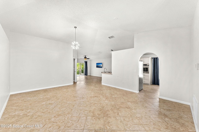2341 Brookshire Cir, Melbourne, FL 32904 - spare room featuring arched walkways, a chandelier, ceiling fan, vaulted ceiling, and light tile patterned floors