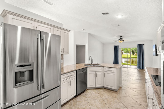 2341 Brookshire Cir, Melbourne, FL 32904 - kitchen featuring stainless steel appliances, a peninsula, a textured ceiling, a ceiling fan, and vaulted ceiling