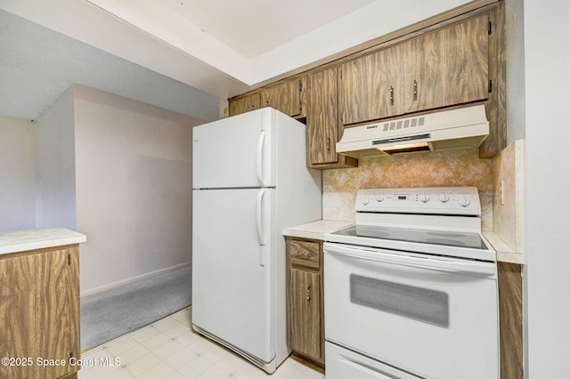 407 Heather Ave NE, Palm Bay, FL 32907 - kitchen with white appliances, under cabinet range hood, light countertops, brown cabinetry, and light flooring
