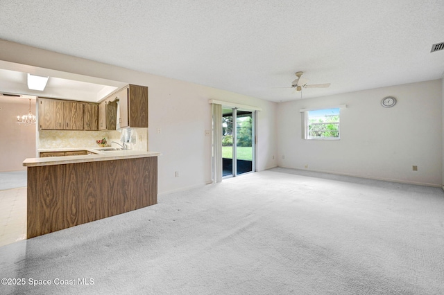 407 Heather Ave NE, Palm Bay, FL 32907 - unfurnished living room featuring a chandelier, a ceiling fan, light carpet, and a textured ceiling