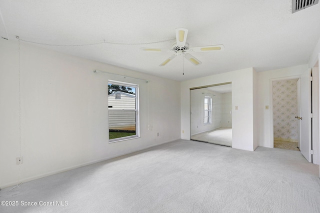 407 Heather Ave NE, Palm Bay, FL 32907 - unfurnished bedroom with multiple windows, light carpet, ceiling fan, and a closet