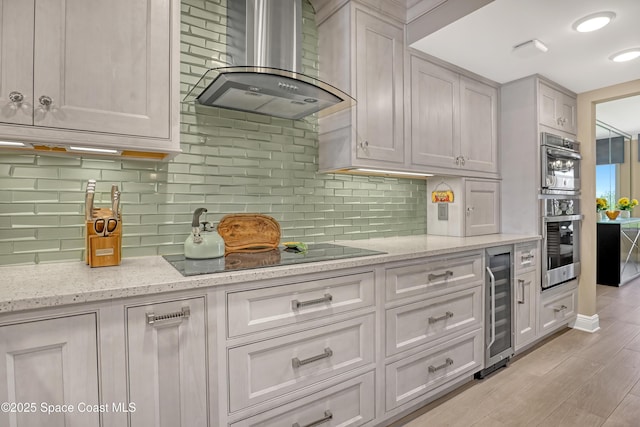 2220 Front St Unit 401, Melbourne, FL 32901 - kitchen featuring wall chimney range hood, beverage cooler, black electric cooktop, double oven, and tasteful backsplash