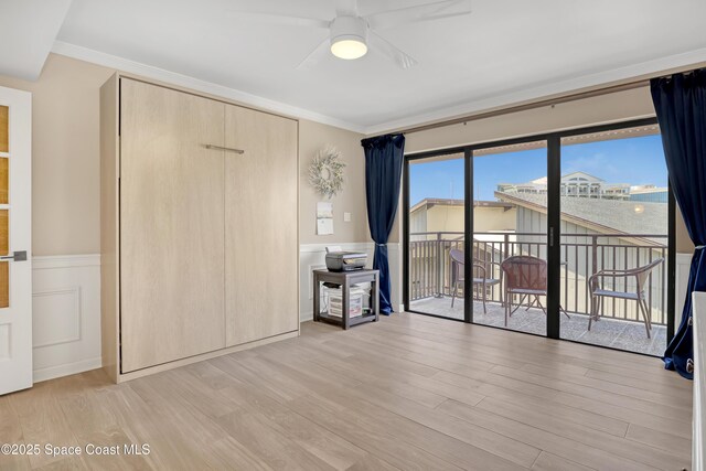 2220 Front St Unit 401, Melbourne, FL 32901 - unfurnished bedroom featuring access to outside, wood finished floors, wainscoting, and crown molding