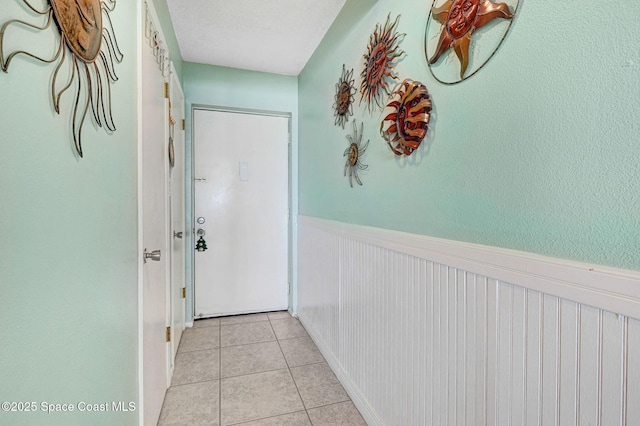2467 S Washington Ave Unit 103B, Titusville, FL 32780 - hallway with wainscoting and light tile patterned flooring