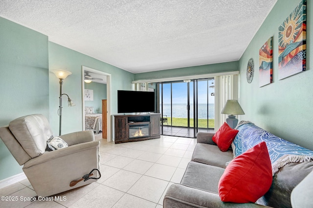 2467 S Washington Ave Unit 103B, Titusville, FL 32780 - tiled living area featuring a glass covered fireplace and a textured ceiling