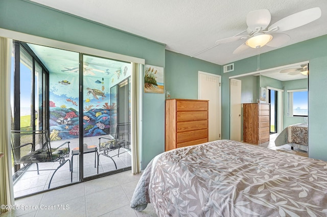 2467 S Washington Ave Unit 103B, Titusville, FL 32780 - tiled bedroom featuring access to exterior, multiple windows, a ceiling fan, and a textured ceiling