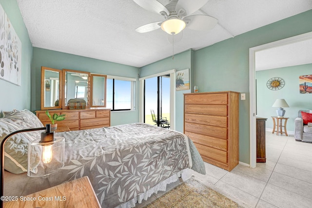 2467 S Washington Ave Unit 103B, Titusville, FL 32780 - tiled bedroom featuring a textured ceiling, access to exterior, and ceiling fan