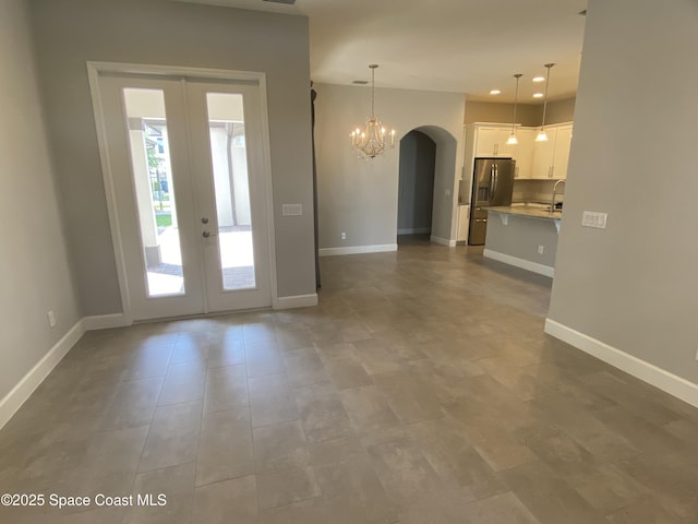 6684 Vista Hermosa Dr, Melbourne, FL 32940 - entrance foyer featuring french doors, arched walkways, a chandelier, and recessed lighting