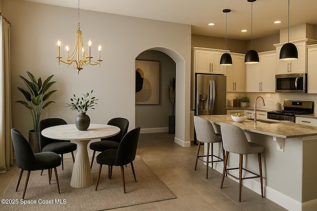 6684 Vista Hermosa Dr, Melbourne, FL 32940 - dining room featuring arched walkways, recessed lighting, and a chandelier