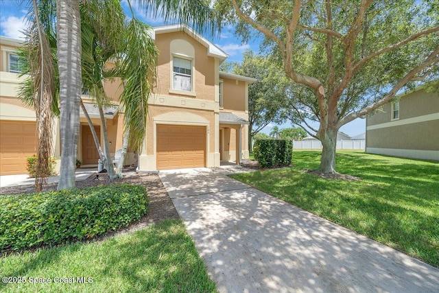 2605 Revolution St Unit 104, Melbourne, FL 32935 - view of front facade with stucco siding, concrete driveway, a garage, and a front lawn