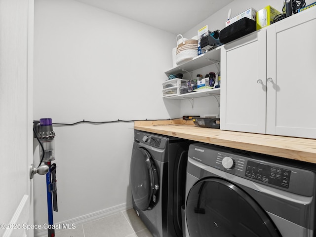 2926 Tishman Rd SE, Palm Bay, FL 32909 - laundry area featuring washing machine and clothes dryer, cabinet space, and light tile patterned floors