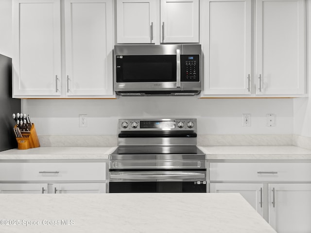 2926 Tishman Rd SE, Palm Bay, FL 32909 - kitchen with appliances with stainless steel finishes, white cabinetry, and light countertops