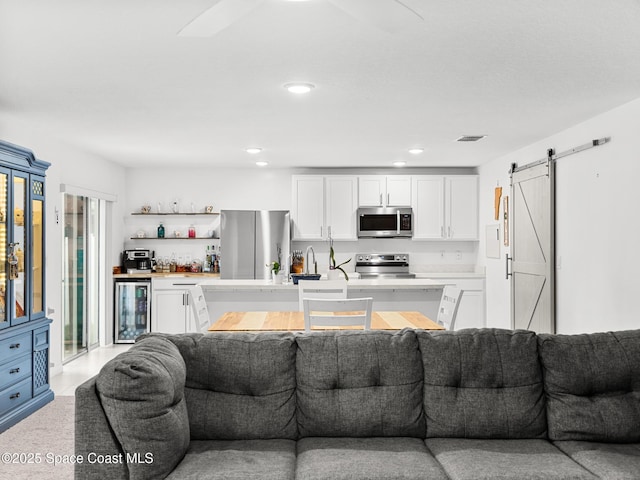 2926 Tishman Rd SE, Palm Bay, FL 32909 - living area with wine cooler, a barn door, bar, and recessed lighting