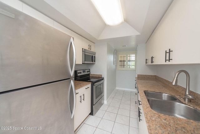 1049 Rockledge Dr Unit 507B, Rockledge, FL 32955 - kitchen with appliances with stainless steel finishes, white cabinetry, light tile patterned floors, and vaulted ceiling
