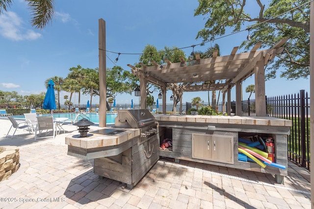 1049 Rockledge Dr Unit 507B, Rockledge, FL 32955 - view of patio featuring a community pool, exterior kitchen, and a pergola