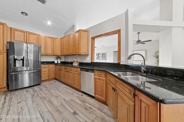 897 Hunters Creek Dr, Melbourne, FL 32904 - kitchen with appliances with stainless steel finishes, light wood-style floors, dark stone counters, a ceiling fan, and vaulted ceiling