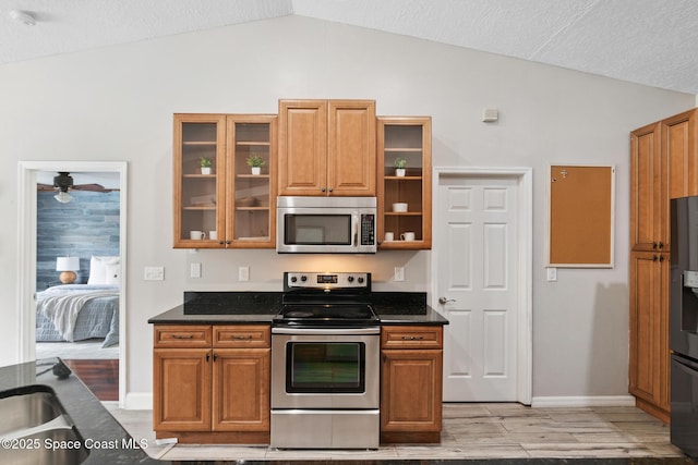 897 Hunters Creek Dr, Melbourne, FL 32904 - kitchen with stainless steel appliances, lofted ceiling, light wood finished floors, glass insert cabinets, and a ceiling fan