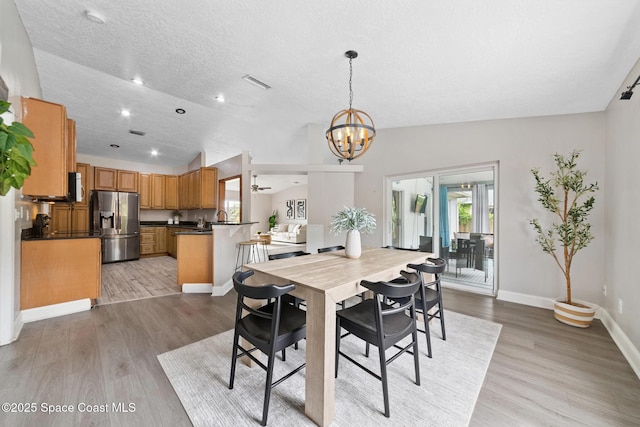 897 Hunters Creek Dr, Melbourne, FL 32904 - dining area with lofted ceiling, a chandelier, light wood finished floors, recessed lighting, and a textured ceiling