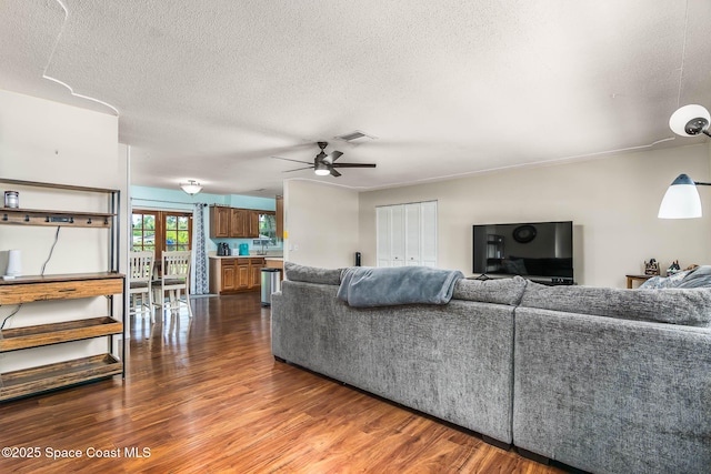 3384 Elizabeth St, West Melbourne, FL 32904 - living area with dark wood-style floors, a textured ceiling, and a ceiling fan