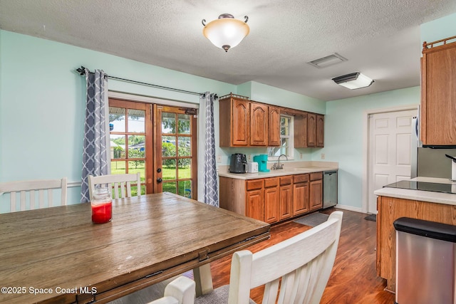 3384 Elizabeth St, West Melbourne, FL 32904 - kitchen with stainless steel dishwasher, a textured ceiling, dark wood-style floors, french doors, and light countertops
