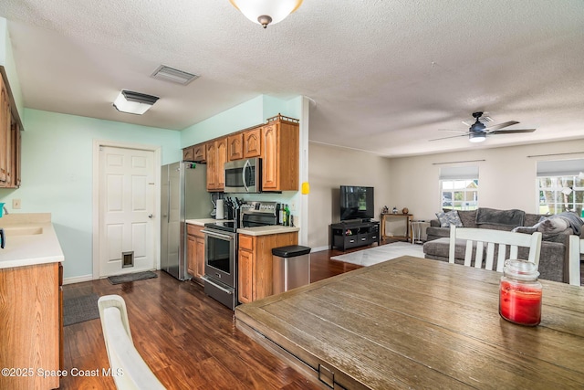 3384 Elizabeth St, West Melbourne, FL 32904 - kitchen with stainless steel appliances, brown cabinetry, light countertops, ceiling fan, and a textured ceiling