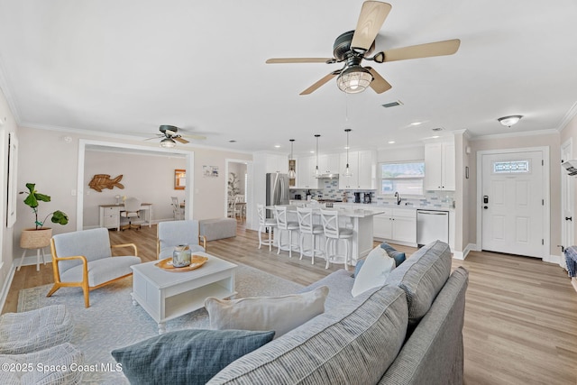 430 Watts Way, Cocoa Beach, FL 32931 - living room featuring a ceiling fan, light wood-style flooring, ornamental molding, and recessed lighting
