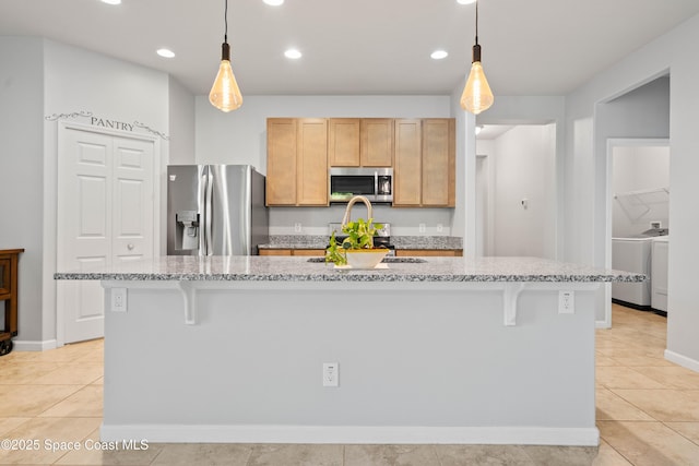 416 Ladyslipper St, Palm Bay, FL 32908 - kitchen featuring appliances with stainless steel finishes, a breakfast bar, washer / clothes dryer, light stone counters, and recessed lighting