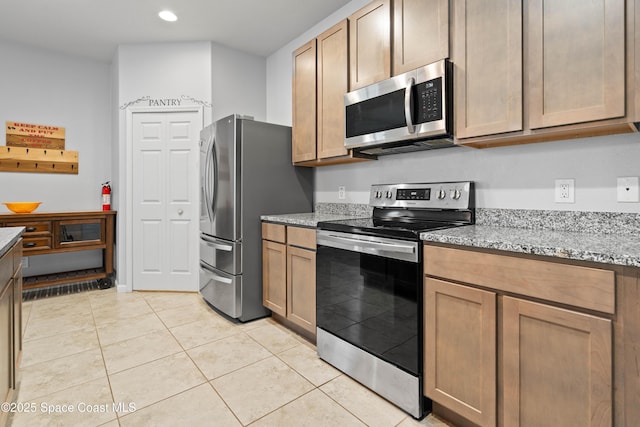 416 Ladyslipper St, Palm Bay, FL 32908 - kitchen with appliances with stainless steel finishes, recessed lighting, light tile patterned flooring, and light stone countertops