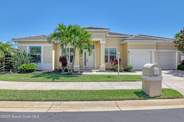 143 Sanibel Way, Melbourne Beach, FL 32951 - view of front of house featuring a garage, concrete driveway, stucco siding, and a tiled roof