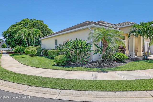 143 Sanibel Way, Melbourne Beach, FL 32951 - view of property exterior with stucco siding and a yard