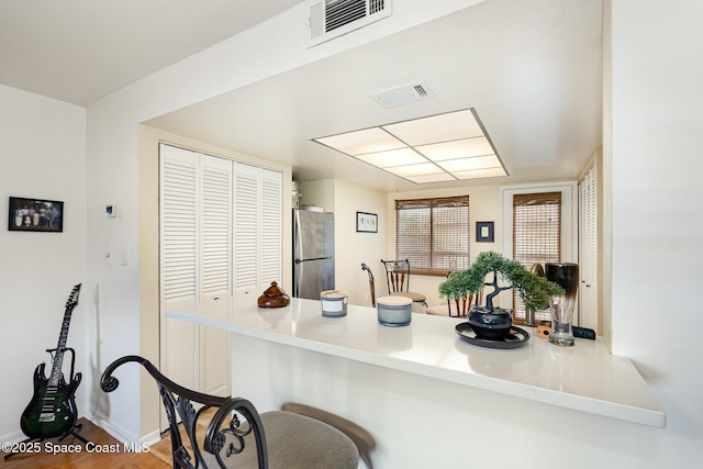 1515 Huntington Ln Unit 423, Rockledge, FL 32955 - kitchen with freestanding refrigerator, a kitchen breakfast bar, a peninsula, and wood finished floors