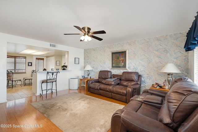 1515 Huntington Ln Unit 423, Rockledge, FL 32955 - living room with wallpapered walls, ceiling fan, an accent wall, and light wood-style floors