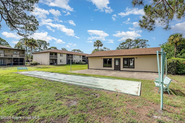 1515 Huntington Ln Unit 423, Rockledge, FL 32955 - rear view of house featuring a lawn and a patio