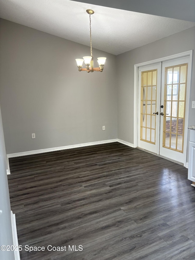 704 Cavio Ave NE, Palm Bay, FL 32905 - spare room with a chandelier, dark wood-type flooring, french doors, and vaulted ceiling