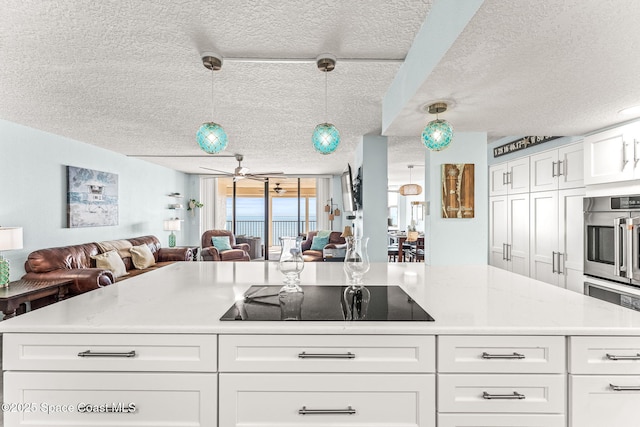 2815 S Atlantic Ave Unit 606, Cocoa Beach, FL 32931 - kitchen with open floor plan, black electric cooktop, a textured ceiling, and light countertops