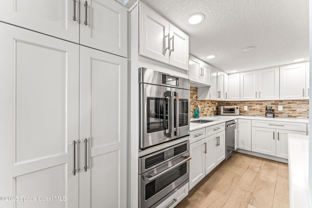 2815 S Atlantic Ave Unit 606, Cocoa Beach, FL 32931 - kitchen featuring dishwasher, a textured ceiling, light countertops, white cabinetry, and tasteful backsplash