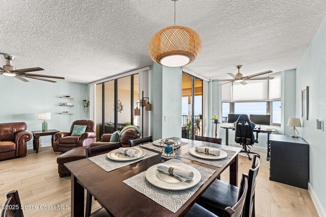 2815 S Atlantic Ave Unit 606, Cocoa Beach, FL 32931 - dining room featuring ceiling fan, light wood-style floors, a textured ceiling, and expansive windows