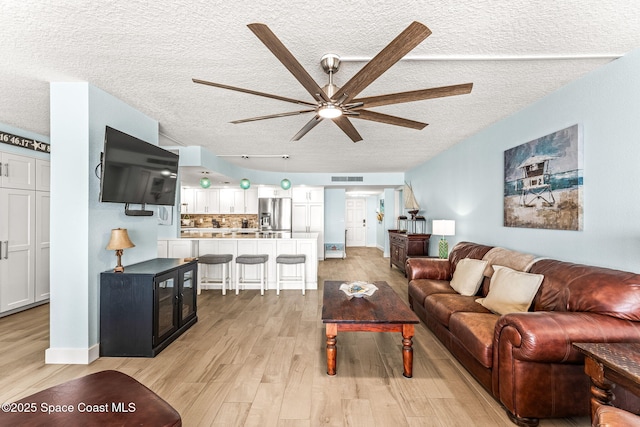 2815 S Atlantic Ave Unit 606, Cocoa Beach, FL 32931 - living room featuring a textured ceiling, ceiling fan, and light wood finished floors