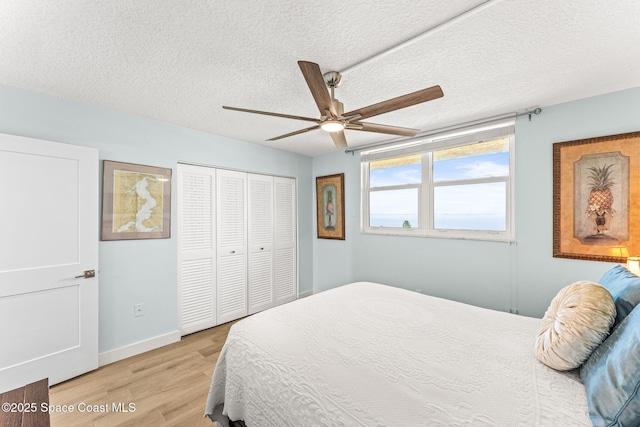2815 S Atlantic Ave Unit 606, Cocoa Beach, FL 32931 - bedroom with light wood finished floors, a closet, a textured ceiling, and ceiling fan